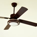 Modern ceiling fan with rubbed bronze hardware and dark wood blades on off-white ceiling